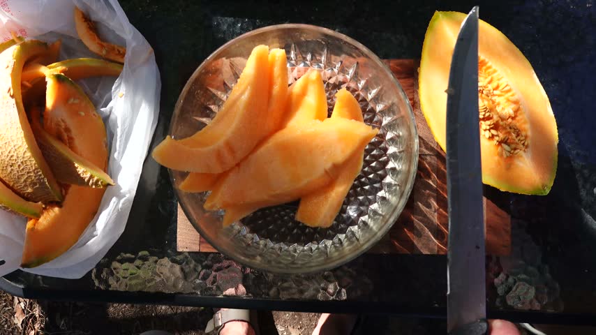 Solomons, Maryland USA An orange and ripe Cantaloupe melon is sliced into a bowl. 