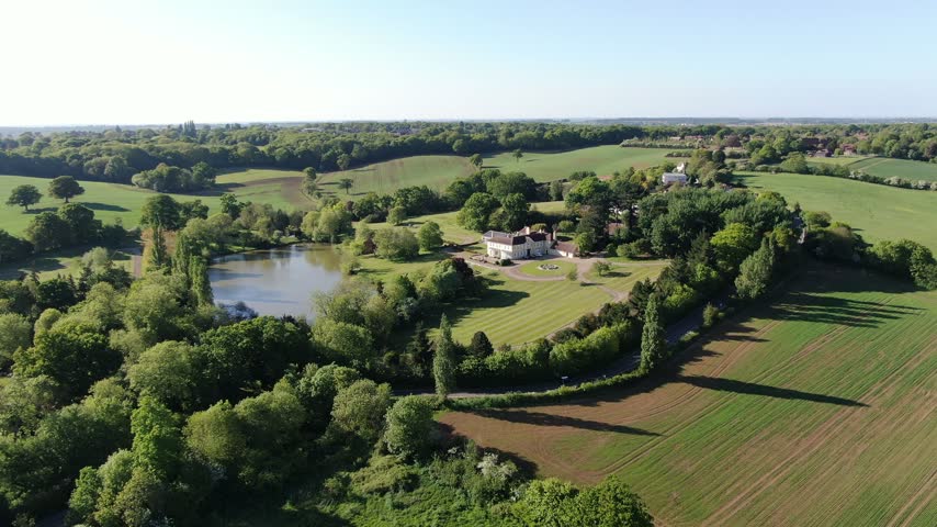 Large house in Essex UK with extensive grounds and lake drone aerial view