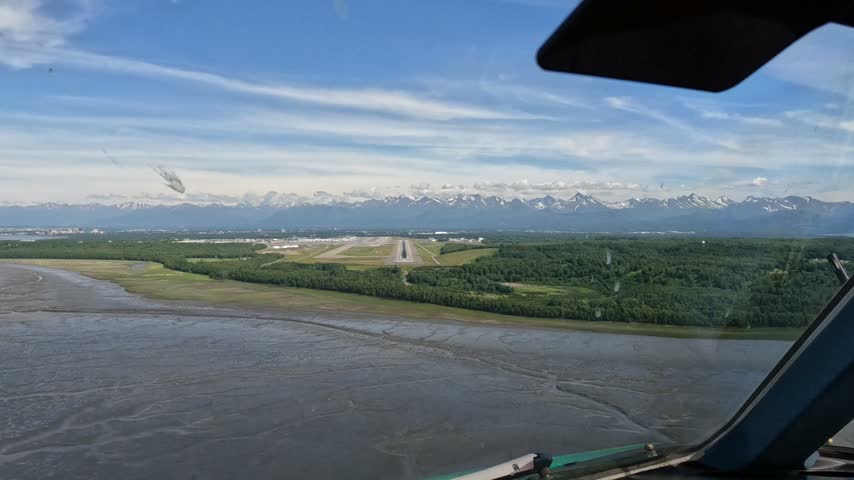 Anchorage, Alaska - approach and landing from Pilots point of view (POV) at Ted Stevens Anchorage International Airport on Runway 25R, Cockpit View with mountain landscape in the background  - 4k aerial video footage