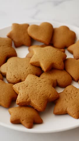 Close-up of homemade star and heart shaped Christmas cookies on plate, festive holiday baking and sweet dessert.