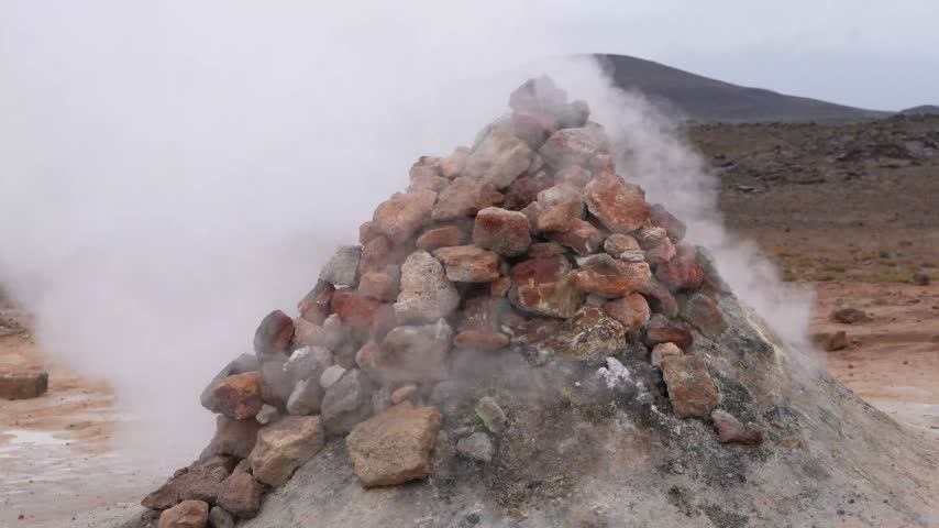 Close up of steam rising from a geothermal vent surrounded by volcanic rocks and barren terrain at Myvatn Iceland