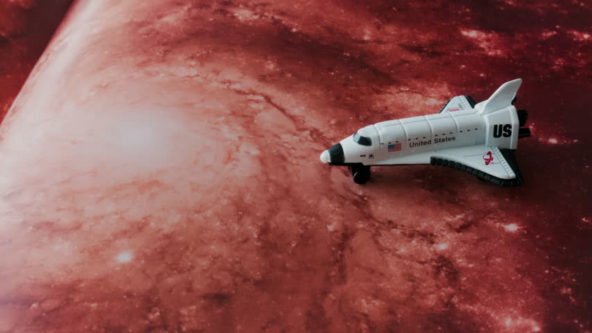 Miniature white United States space shuttle model positioned stationary on a vibrant textured deep space nebula backdrop. Cinematic overhead view capturing exploration concepts.