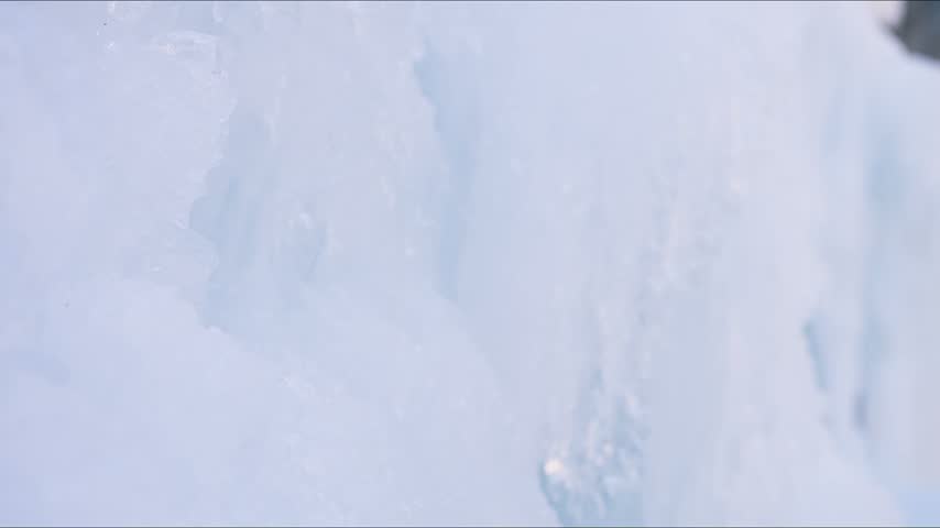 POV ice climber swinging an ice axe into a frozen mountain surface, capturing an intense winter climbing adventure and challenging outdoor mountaineering experience.