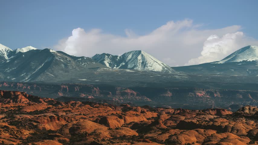 Time lapse panorama of Arches National Park desert plateau with distant snow capped La Sal Mountains, Utah, USA.