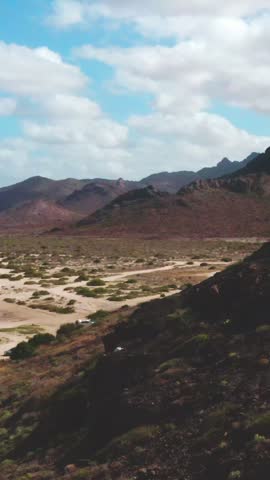 Aerial drone flyover over rugged desert mountains and dirt trails, Baja California Sur, Mexico