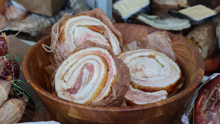 Traditional Rolled Cured Pork Fat with Meat and Spices at Street Food Market. Artisan Meat Delicacy. Rolled Salo
