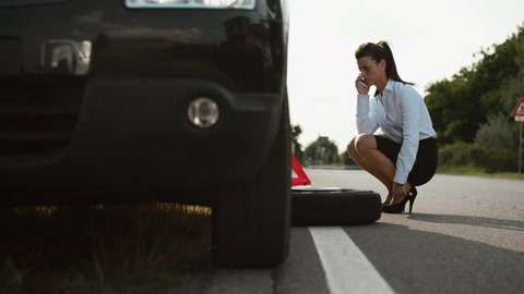 Woman, female driver, emergency and driving problems, frustrated girl with flat car tyre calling tow truck for help and assistance