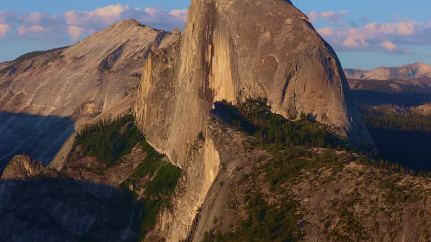 Golden sunset light glows across the panoramic view of Half Dome from Glacier Point in Yosemite National Park
