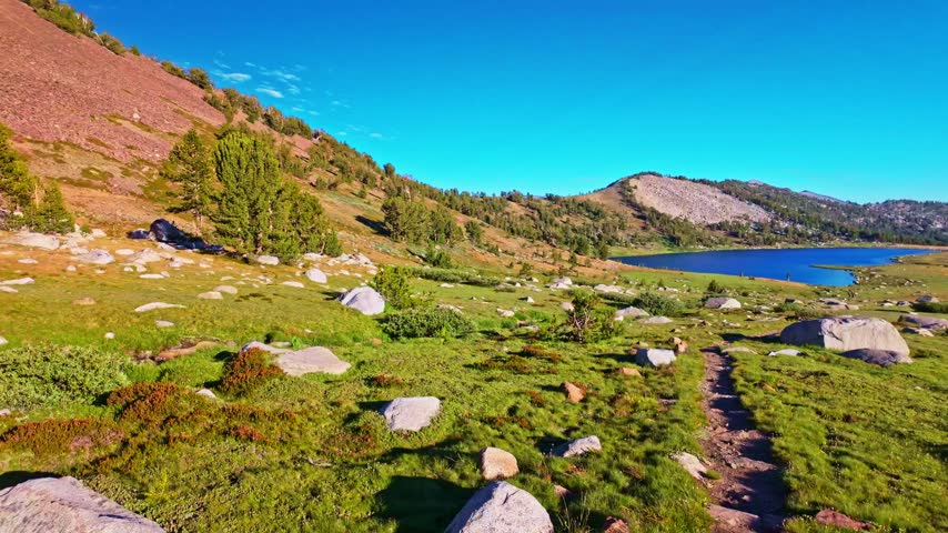 Scenic panoramic view of Middle Gaylor Lake reflecting the warm golden light of sunset in Yosemite National Park, California