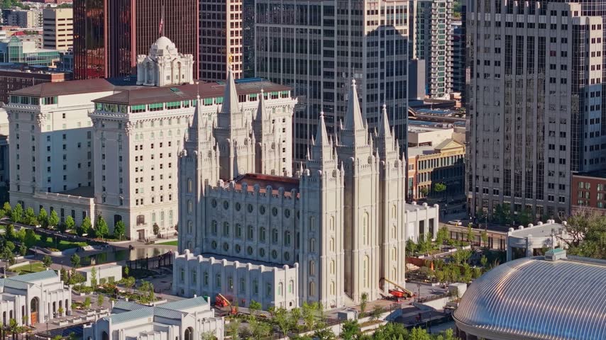 Golden sunrise light glows over the panoramic aerial view of the Salt Lake Temple at Temple Square