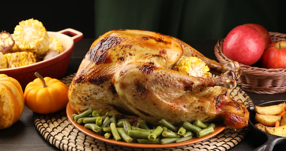 Thanksgiving Day. Woman taking delicious turkey with green beans from wooden table, closeup
