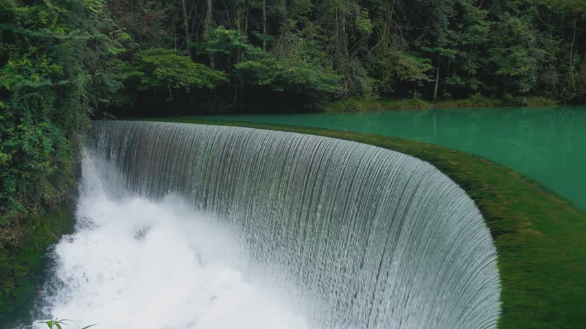 Real shot of the arc water curtain landscape of Huangguoshu Waterfall in Guizhou China. The water pours down along the arc terrace, forming a half ring silver curtain, with unique and highly impactful visual effect.