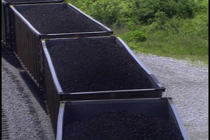 Train hauling 120 cars loaded with coal, tilt up to transformers and power lines from power plant in Rockport, Indiana.