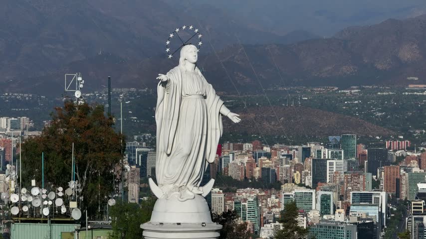 The statue of the Virgin of Santiago from San Cristóbal Hill Santiago, Chile and the aerial view of the Andes Mountains
