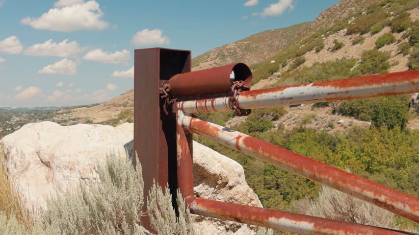 Static close view of a rusted metal gate at a mountain hiking trail.