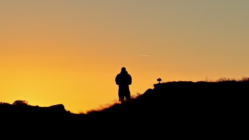 Photographer silhouette photographing the sun rising over the Col d