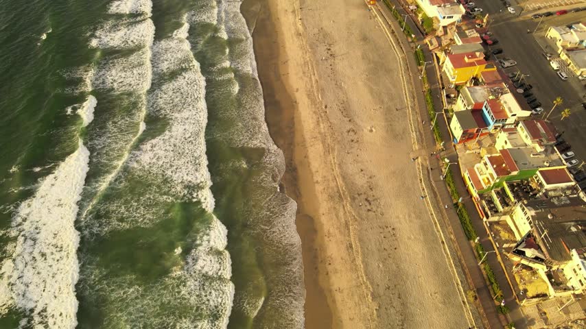 Aerial drone view of US Mexico border wall extending into Pacific Ocean between Tijuana and San Diego