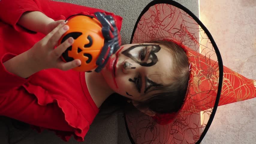 Kids trick or treat in Halloween costume. kids with a basket for sweets. A boy in a skeleton a girl in a witch costume. Children are having fun playing with balloons and laughing at holiday in autumn.