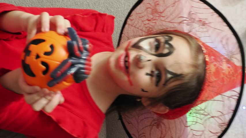Kids trick or treat in Halloween costume. kids with a basket for sweets. A boy in a skeleton a girl in a witch costume. Children are having fun playing with balloons and laughing at holiday in autumn.