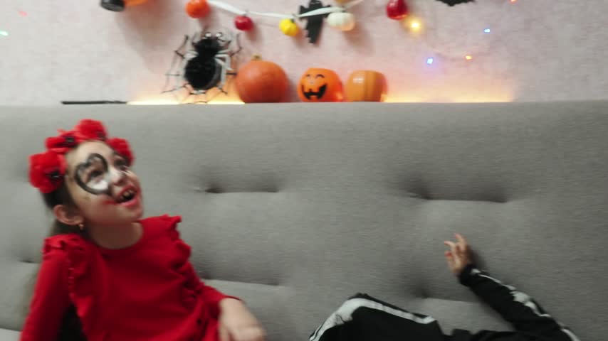 Kids trick or treat in Halloween costume. kids with a basket for sweets. A boy in a skeleton a girl in a witch costume. Children are having fun playing with balloons and laughing at holiday in autumn.