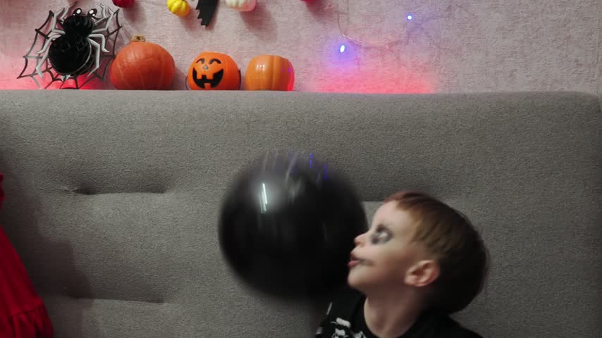 Kids trick or treat in Halloween costume. kids with a basket for sweets. A boy in a skeleton a girl in a witch costume. Children are having fun playing with balloons and laughing at holiday in autumn.