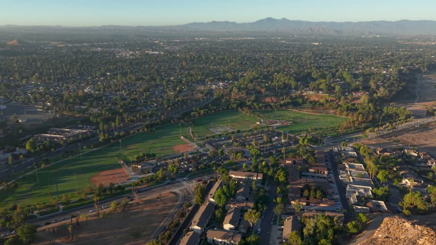 Aerial view of green park fields and surrounding Riverside neighborhoods at sunset