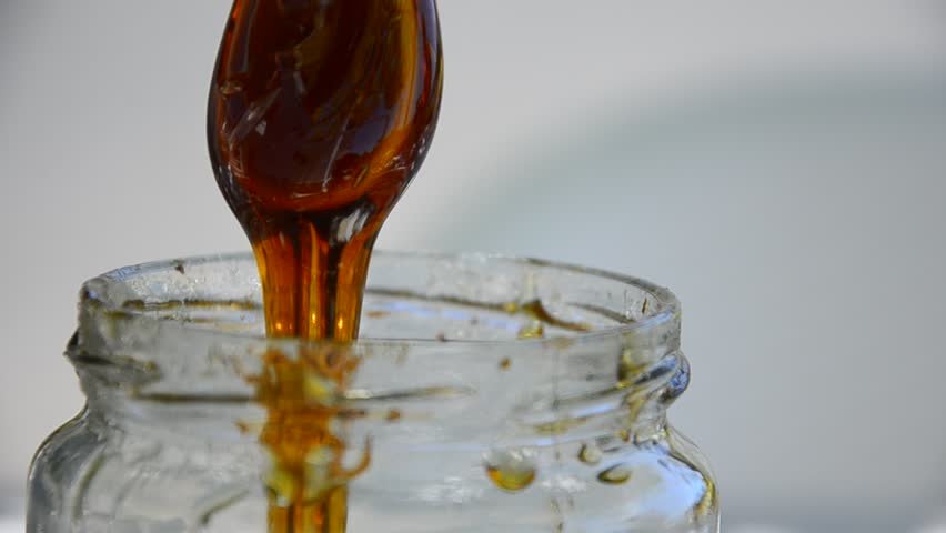 Honey drip in jar on the table, Close up