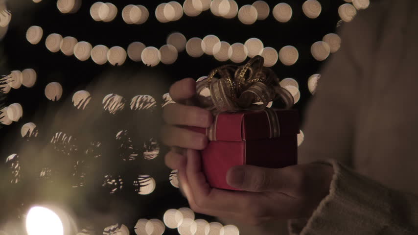 Opening Small Christmas present, gift shining with magic light