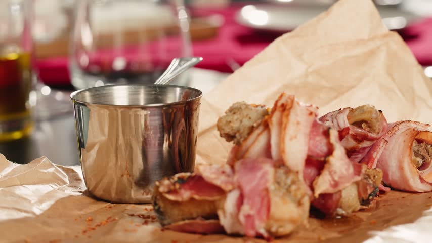 Fried bacon roll served in a beer pub restaurant, close up of crispy grilled bacon snack, tasty meat appetizer for beer in a cozy gastropub.