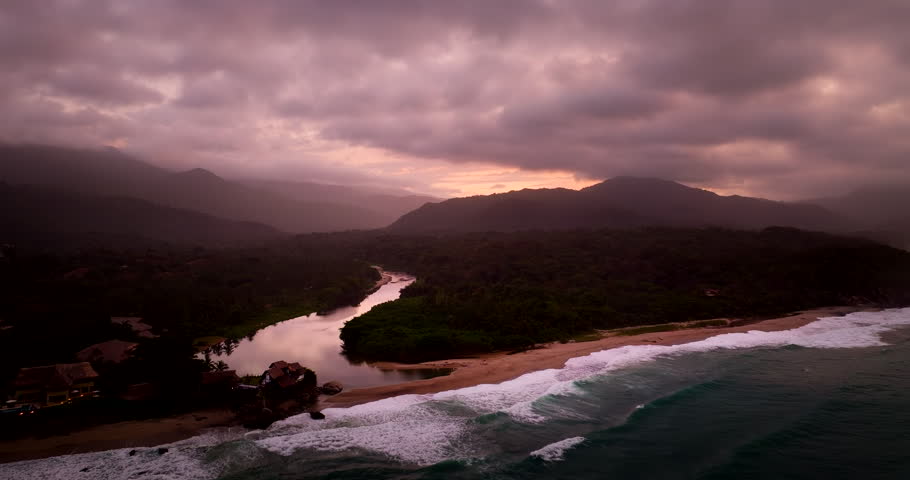Sunset aerial view over Tayrona Los Naranjos river meeting sandy beach coastline