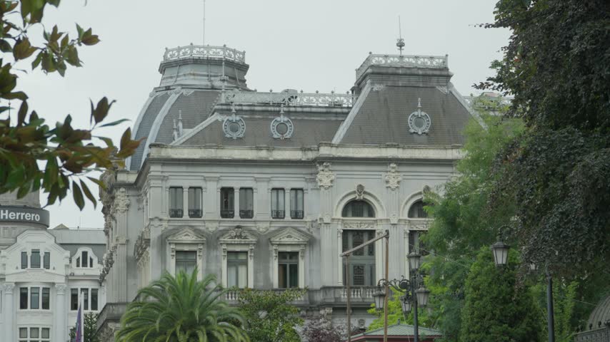 Ornate historical architecture of a white government palace. Majestic facade with intricate details surrounded by lush green trees