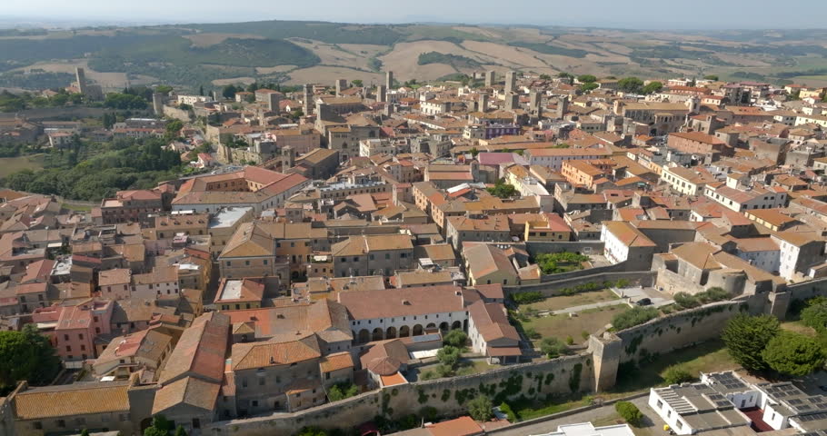 Panoramic view of Tarquinia, in the province of Viterbo, in Lazio, Central Italy, with the stone walls of the historic center, and the hills of the countryside behind.