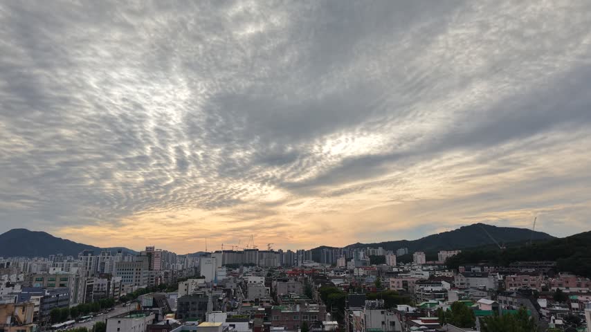 Dramatic sunset sky over a dense city skyline and mountains in South Korea