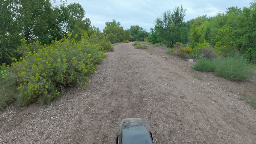 Looking back - POV from recumbent trike ride on a rough gravel trails along the Poudre River in Fort Collins, Colorado - late summer scenery in Riverbend Ponds Natural Area