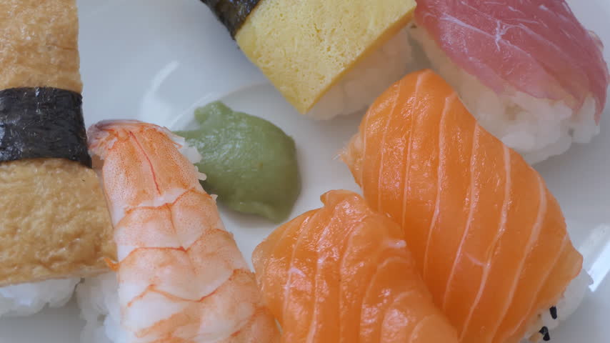 An assortment of fresh sushi nigiri with wasabi served on a plate.