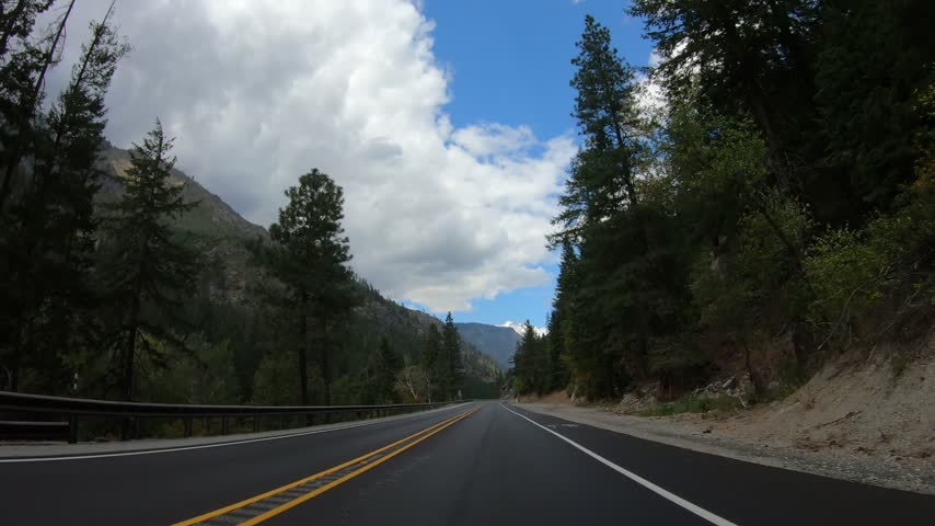 Driving Plate POV Washington State Pacific Northwest Road to Lake Wenatchee. Beautiful Day Winding Paved Highway, Mountains, Trees, Forest, Blue Sky 2