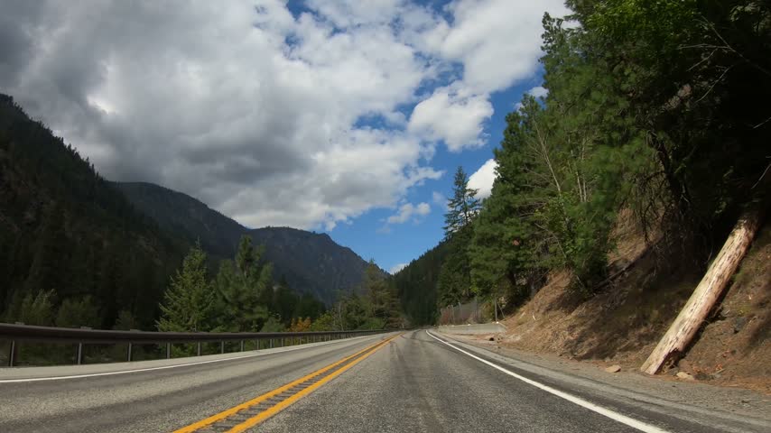 Driving Plate POV Washington State Pacific Northwest Road to Lake Wenatchee. Beautiful Day Winding Paved Highway, Mountains, Trees, Forest, Blue Sky