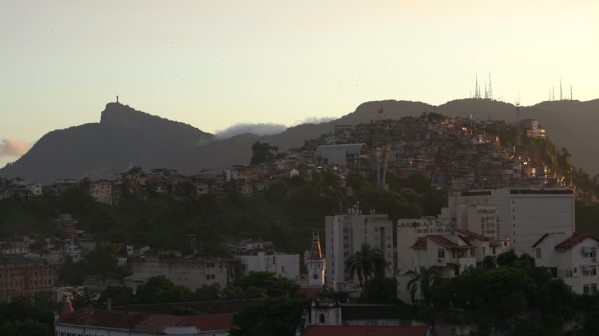 Rio de Janeiro, Brazil Sunset View From Cruise Ship. Christ the Redeemer Statue on Mountain. Warm Light, City Neighborhood Buildings.