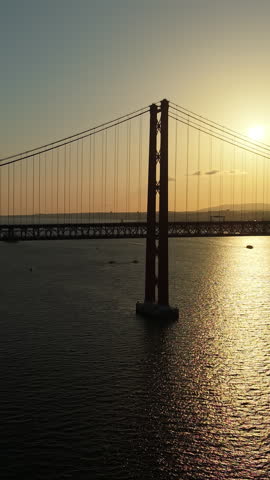 25 April Bridge at sunset in Lisbon Silhouette of the 25 April Bridge over the Tagus River during sunset in Lisbon, Portugal. 