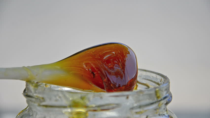 HONEY being POURed INto glass JAR, Close up
