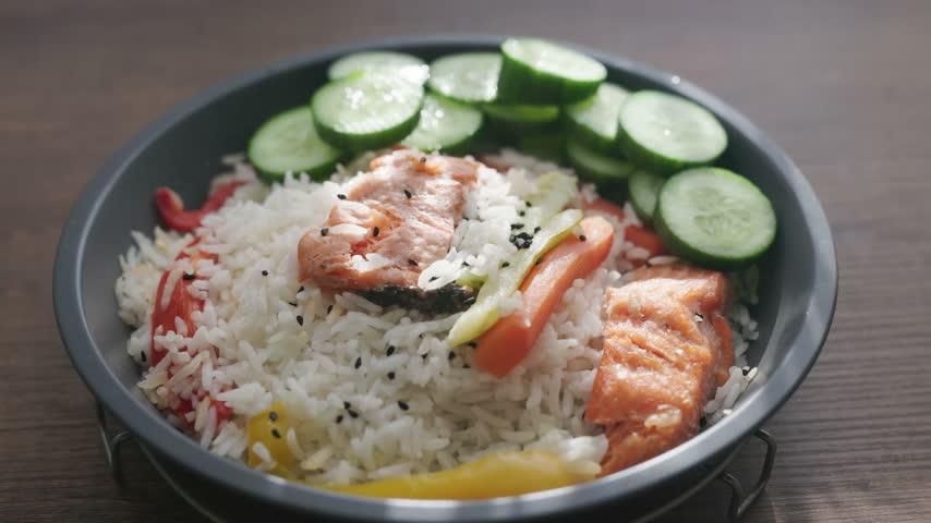 healthy salmon fillet served with rice and steamed vegetables