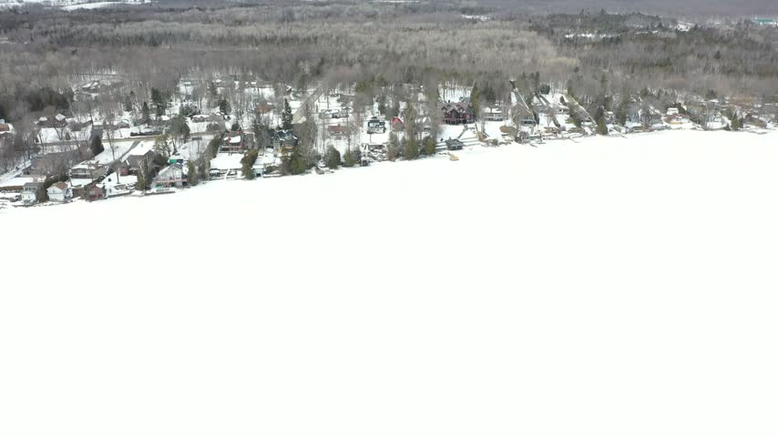 Aerial View of Snow Covered Lakeside Homes in Winter.