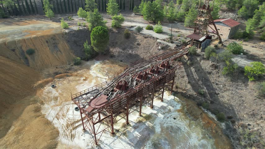 Drone Aerial footage slowly pulling back from the rusty, abandoned structures of the mitsero mine in cyprus