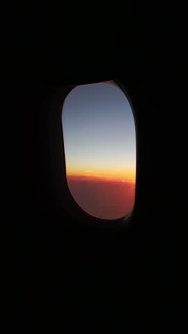 View from airplane window looking at sunset sky.