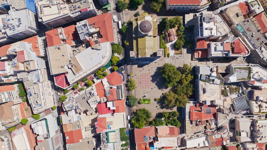 Top-down aerial rotating view of the historic Monastiraki square and the Tzistarakis Mosque in the bustling city center of Athens, Greece, showcasing the urban landscape and ancient landmarks