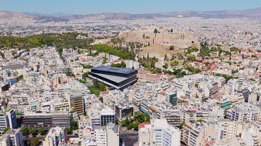 Stunning aerial panorama of Athens showing the ancient Acropolis and Parthenon rising above the modern cityscape on a sunny day, showcasing a blend of history and contemporary urban life
