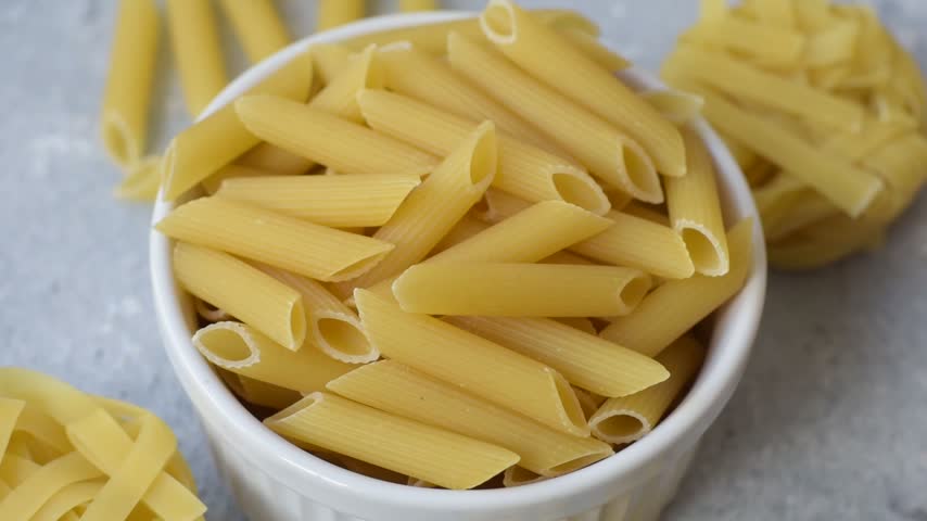 Italian uncooked dry penne regate pasta ready for cooking. Dry penne pasta