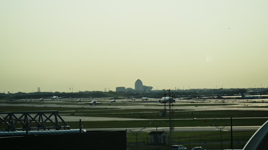 Sunset over Chicago International Airport with glowing horizon, airport control tower, airplane taking off from
