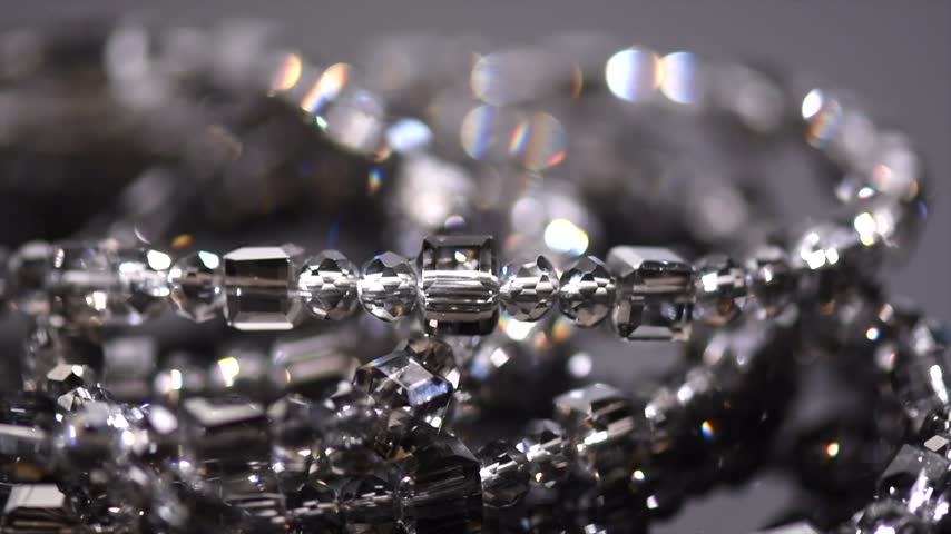 Crystals bracelet or necklace, gems, diamonds over black background, beautiful gems, rhinestones, brilliants sparkling with colorful caustics, rainbow lights. Moissanite. Zirconia 