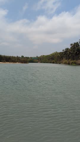 Scenic view of calm backwaters surrounded by green trees and blue sky